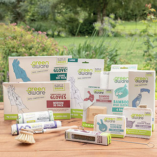 GreenAware products displayed on a wooden table in front of a garden