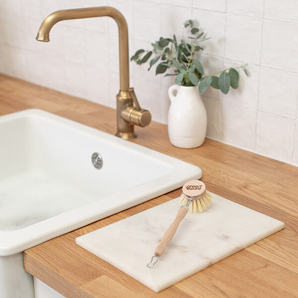 Wooden dish brush sitting on top of a counter-top